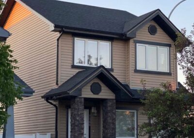 Roofing project in Regina showing a professional roofer installing asphalt shingles on a residential home.
